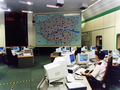 A historic photo of the old Control Room. There is a large map of London on the wall, and officers sat at desks in front of large 90s-style computers.
