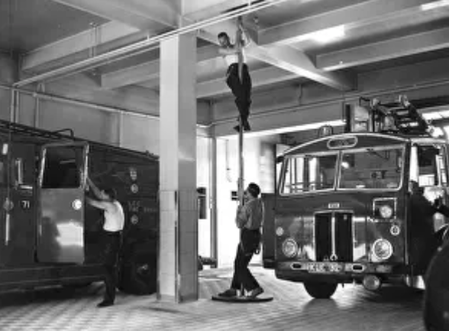 Man coming down on a rope with a fire engine 